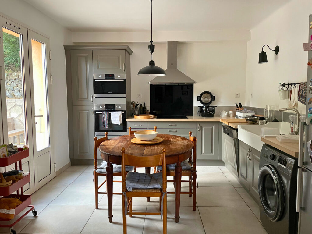 Cuisine rénovée mêlant carreaux de ciment bleus, crédence rétro et îlot optimisé